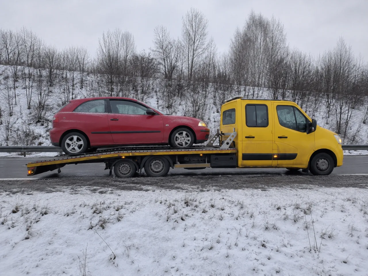 Laweta z autem w zimowej scenerii – holowanie Ełk