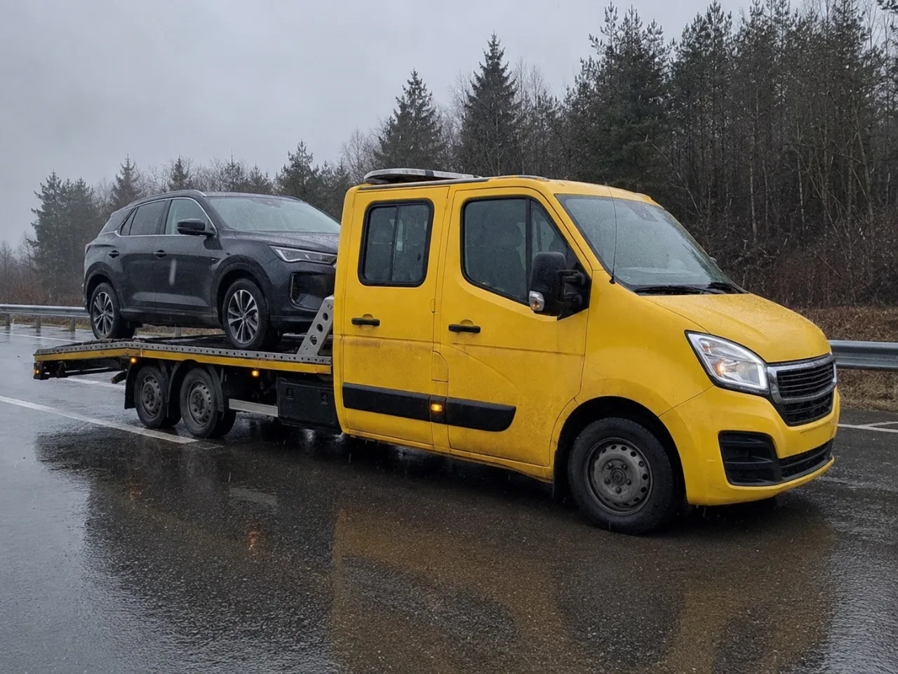 SUV zabierany na lawetę w deszczu – wymiana koła Ełk